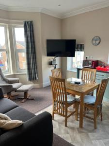 a living room with a wooden table and chairs at Armada Apartment in Redcar