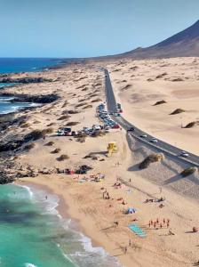 una vista aérea de una playa con personas y coches en Grandes Playas, en Corralejo