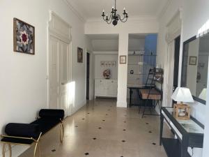 a living room with a chandelier and a table and chairs at Les Hôtes d’Eloise in Laon