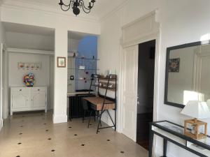 a living room with a table and a desk at Les Hôtes d’Eloise in Laon