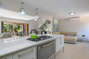 cocina con fogones horno superior junto a la sala de estar en Villa 2811 Luxurious and Modern at Upmarket Golf and Beach Estate, en Marina Beach