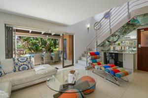 ein Wohnzimmer mit einem Sofa und einem Glastisch in der Unterkunft Luxurious Modern Villa at Upmarket Golf and Beach Estate in Marina Beach