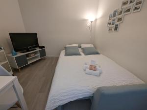 a bedroom with a bed with a teddy bear on it at Hypercentre, au calme, 5 min de la plage : KERDAMEZ ! in Dinard