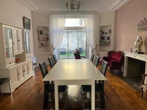uma sala de jantar com uma mesa branca e cadeiras em Les Hôtes d’Eloise em Laon