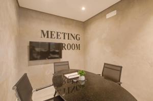 uma sala de jantar com uma mesa e uma sala de reuniões em Roomo Brooklin Morumbi Ejoy Residencial em São Paulo
