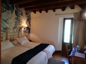 a bedroom with two beds and a window at Posada Rural Peñasagra in Quintanilla