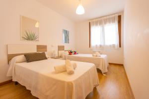 a room with two beds and a window at Apartagal-Playa de Llas, Foz in Foz