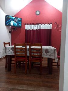 ein Esszimmer mit einem Tisch und Stühlen sowie einem TV in der Unterkunft El Piscui House in Merlo