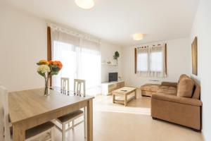 a living room with a table and a couch at Apartagal-Playa de Llas, Foz in Foz
