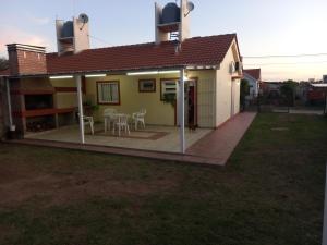 ein Haus mit einer Terrasse mit Stühlen und Tischen in der Unterkunft El Piscui House in Merlo
