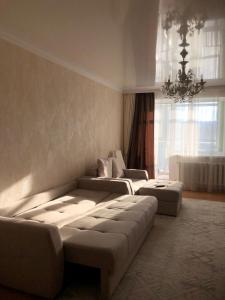 a living room with two couches and a chandelier at at HOME in Prigorodnyy