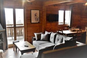 uma sala de estar com um sofá e uma mesa em Grand chalet en bois avec vue splendide em Le Dévoluy