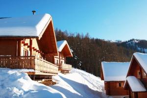 uma cabana de madeira na neve com neve em Grand chalet en bois avec vue splendide em Le Dévoluy