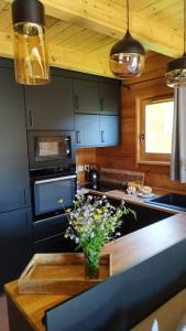a kitchen with a table with a vase of flowers on it at Grand chalet en bois avec vue splendide in Le Dévoluy