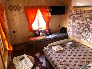 Habitación con 2 camas, sofá y ventana en Bear House Uludağ Bungalov en Hüseyinalan