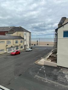 a street with cars parked on the beach at Armada Apartment in Redcar
