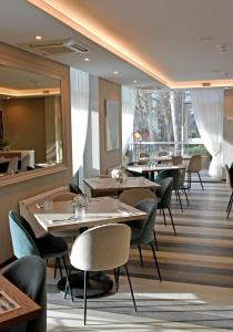 un restaurante con mesas y sillas y una gran ventana en Grand Baltic Dunes en Palanga