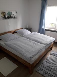 two beds in a bedroom with a window at Ferienwohnung Brehmbachgrund in Tauberbischofsheim