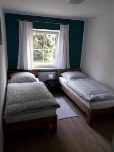 a bedroom with two beds in front of a window at Ferienwohnung Brehmbachgrund in Tauberbischofsheim