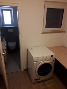 a small bathroom with a washing machine and a window at Ferienwohnung Brehmbachgrund in Tauberbischofsheim