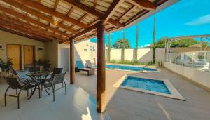 a patio with a table and chairs and a swimming pool at Pousada Recanto das Caldas in Caldas Novas