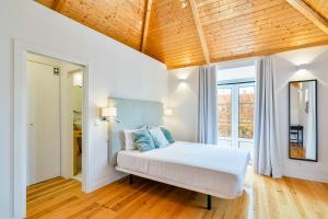- une chambre avec un lit et un plafond en bois dans l'établissement Central Premium, à Setúbal