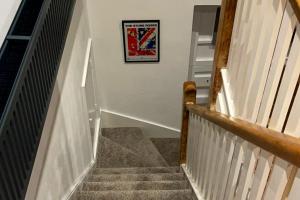 a stairway with a picture hanging on a wall at Stunning Luxury Apartment in Central Lymington in Lymington +40 photos