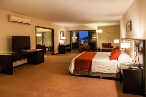 a hotel room with a bed and a flat screen tv at Howard Johnson Hotel & Casino in Formosa