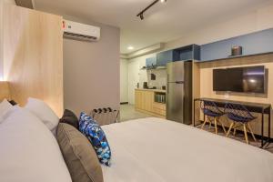 Roomo Brooklin Morumbi Ejoy Residencial tesisinde bir odada yatak veya yataklar