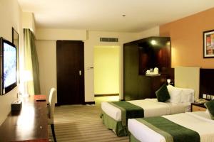 リヤドにあるBusiness Inn Olayaのベッド2台、薄型テレビが備わるホテルルームです。