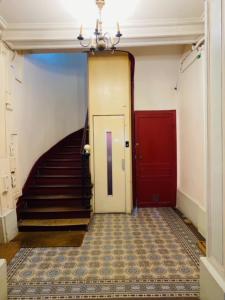 a hallway with a staircase and a red door at Warm 18m ideal for couple in Paris in Paris