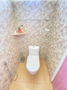 a bathroom with a toilet in a tiled room at Hana Homestay in Pendang
