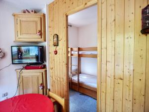 a small room with a bunk bed and a bedroom with a tv at Appartement Les Menuires, 3 pièces, 6 personnes - FR-1-178-32 in Les Menuires