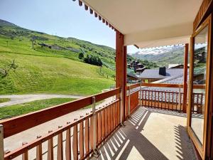 a balcony with a view of a green hill at Appartement Les Menuires, 3 pièces, 6 personnes - FR-1-178-32 in Les Menuires