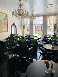 un ristorante con tavoli, sedie e lampadario a braccio di My Place Hotel a Londra