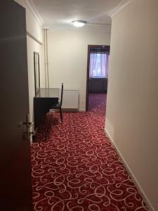 a hallway with a red carpeted floor and a piano at Ankara apart Hostel 2 in Altındağ