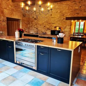 a kitchen with blue cabinets and a stove top oven at Moulin de Saint Avit in Gavaudun