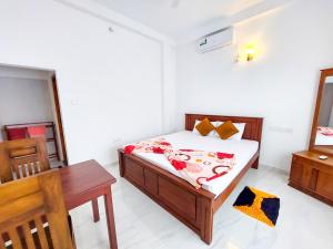 Un dormitorio con una cama y una mesa. en Kavi Villa, en Bentota