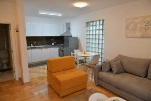 Prokuplje的住宿－Apartmani TEO，带沙发和椅子的客厅以及厨房。