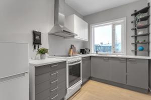 una cocina con electrodomésticos blancos y una ventana en Sunny Reykjavík Apartment, en Reikiavik