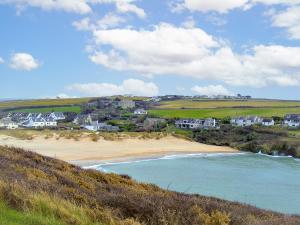 a view of a beach with houses on a hill at Chynoweth in Saint Merryn