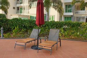 two chairs and an umbrella on a patio at 1. Luxury Kristal condo 1 丹绒亚路市中心高級住宅 in Kota Kinabalu