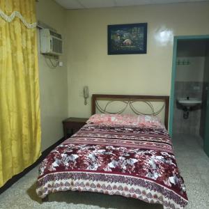una camera da letto con un letto con un copriletto sopra di HOTEL PRIMAVERA a Guayaquil