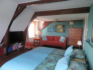 - une chambre avec un grand lit et un canapé rouge dans l'établissement Het Burgemeestershuis, à Barsingerhorn