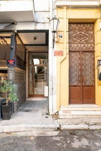 - un bâtiment avec une grande porte en bois dans une rue dans l'établissement OpenAir HOT TUB/Big Balcony/Great Boutique Apt, à Athènes