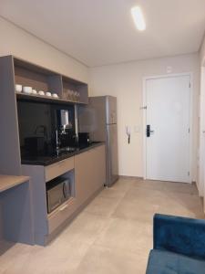 a kitchen with a refrigerator and a stove top oven at Cityhome Platina Tatuapé in Sao Paulo