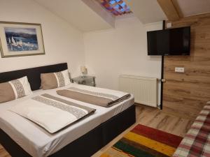 een slaapkamer met een bed en een flatscreen-tv bij Hotel Gletschermühle in Flattach