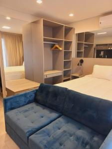 a bedroom with a bed and a blue couch at Cityhome Platina Tatuapé in Sao Paulo