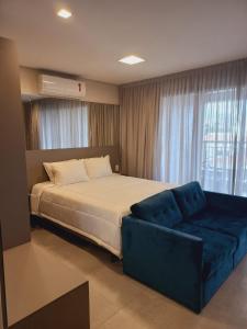 1 dormitorio con 1 cama y 1 sofá azul en Cityhome Platina Tatuapé, en São Paulo