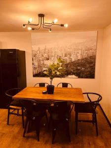 a dining room table with chairs and a painting on the wall at 'Woodbury' at stayBOOM in Lancaster